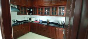 a kitchen with wooden cabinets and black counter tops at Suite Room in Apartments in Bangalore