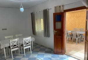 a dining room with a table and chairs and a door at Maison avec terrasse et spa in Oujda