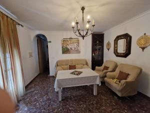 uma sala de estar com um sofá e uma mesa em El Aroma del Dulce em Setenil de las Bodegas