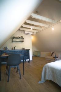 um quarto no sótão com uma secretária e uma cama em WetterLoft - Luxe appartement met aanlegsteiger en terras em Terherne