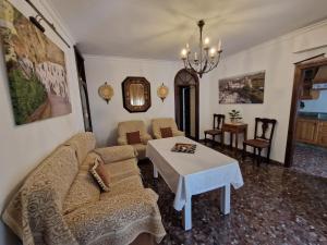 uma sala de estar com um sofá e uma mesa em El Aroma del Dulce em Setenil de las Bodegas