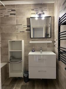 y baño con lavabo blanco y espejo. en Appartement 50m2 vue imprenable avec garage draps et serviettes compris en Villard-de-Lans