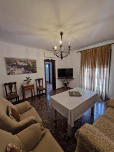 uma sala de estar com um sofá e uma mesa em El Aroma del Dulce em Setenil de las Bodegas