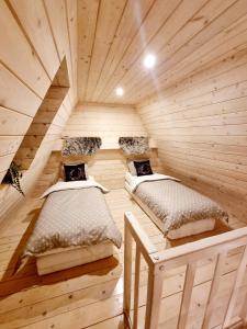 um quarto com 2 camas num chalé de madeira em Domki Żabiniec em Jedle