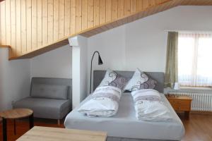 Una cama con almohadas y una silla en una habitación. en Ferienwohnungen Walserhof Malbun en Malbun