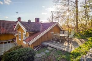 a house with a wooden deck with a table and chairs at Outstanding apartment close to Gothenburg in Kungälv