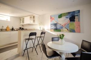 a kitchen with a white table and chairs in a room at Outstanding apartment close to Gothenburg in Kungälv