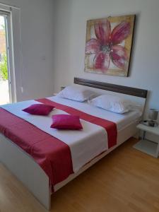 a bedroom with a large bed with red and white pillows at Apartment Šime Bibinje in Bibinje