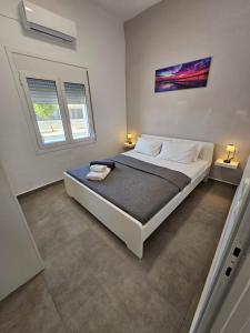 um quarto com uma cama grande e 2 janelas em Villa Sakrakis seaview villa em Stavros