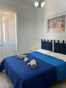 una camera da letto con un letto blu e asciugamani di Mare & Scogli a Polignano a Mare