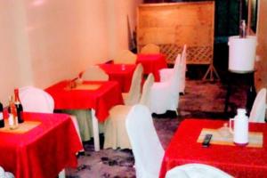 a room with red and white tables and chairs at Safari Park House in Arusha