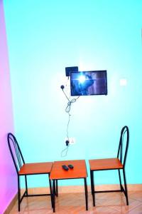 due sedie e un tavolo con una telecamera su un muro di Safari Park House ad Arusha