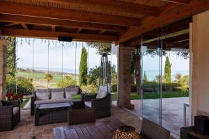a patio with a view of the ocean through glass at Colle degli ulivi Green Resort in Petacciato