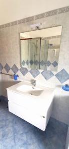 ein Badezimmer mit einem weißen Waschbecken und einem Spiegel in der Unterkunft Path of gods in Pianillo
