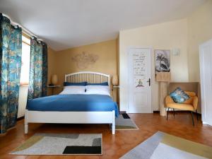 a bedroom with a blue bed and a chair at Villa Gisi Guest House in Fiumicino