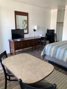 a hotel room with a desk and a bed at John Day Motel in John Day