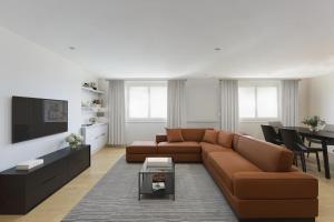 a living room with a brown couch and a table at Comfy 2 Bedrooms by Natural History Museum in London