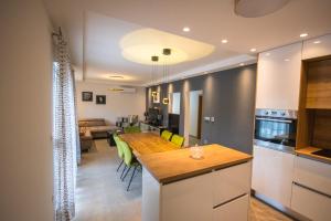 イモツキにあるLUXURY Apartment IMOTA,with private pool,big Free Parking,Car EVchargerのキッチンとテーブルとソファのあるリビングルーム