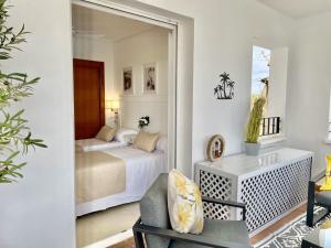 Una habitación con un dormitorio con una cama y un espejo. en Casa Kevin - Hacienda Riquelme Golf Resort, en Sucina