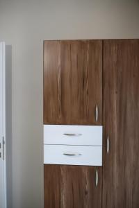 a wooden cabinet with two white drawers on it at Our Home-Fully renovated apartments and studios by the sea in Nikiti