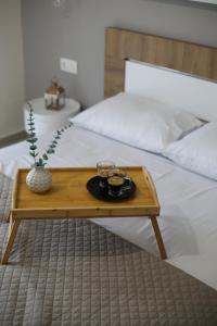 a wooden tray with two cups on a bed at Our Home-Fully renovated apartments and studios by the sea in Nikiti