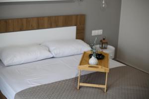 a bedroom with a white bed and a wooden table at Our Home-Fully renovated apartments and studios by the sea in Nikiti