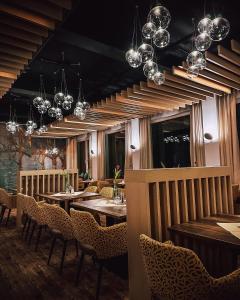 a restaurant with wooden tables and chairs and chandeliers at Hotel zum Engel in Mespelbrunn