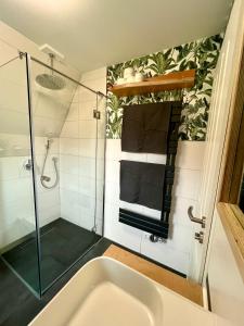 a bathroom with a shower and a bath tub at Finnhütten am Storkower See - Urlaub in der Natur in Storkow