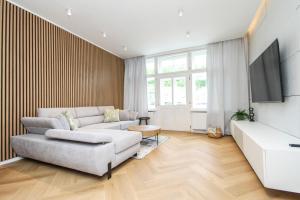 uma sala de estar com um sofá e uma televisão em Apartmán Vita Design em Trenčín