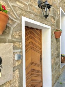 una puerta de madera en una pared de piedra con plantas en HÖTEL U SANTA MARIA, en Olmeto