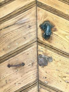 a wooden door with a metal door knocker on it at HÖTEL U SANTA MARIA in Olmeto