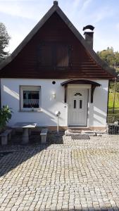 ein weißes Haus mit einer Tür und einer steinernen Einfahrt in der Unterkunft Ferienwohnung Hähnlein in Steinach