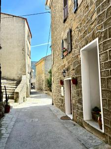 an alley in an old stone building with two doors at HÖTEL U SANTA MARIA in Olmeto