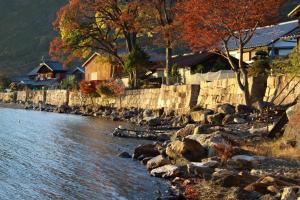 a river with rocks and trees and houses at sikari Vacation STAY 95401v in Takashima