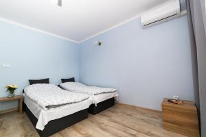 1 dormitorio con 2 camas y suelo de madera en Apartament Na Bajkowej en Busko-Zdrój