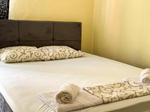 a bed with two folded towels on it at Venera Apartman in Škaljari