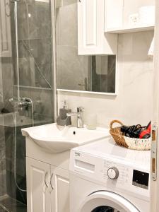 a white bathroom with a washing machine and a sink at Venera Apartman in Škaljari +19 photos