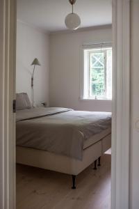 - une chambre avec un grand lit et une fenêtre dans l'établissement Vallby Cottage, à Enköping