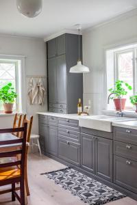 una cocina con armarios grises y fregadero en Vallby Cottage, en Enköping
