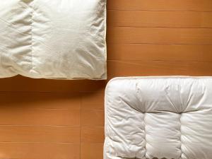 ein Bett mit weißer Bettwäsche neben einer Wand in der Unterkunft sikari Vacation STAY 95401v in Takashima