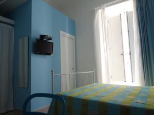a blue bedroom with a bed and a window at L'alberghetto Casavacanza Milazzo in Milazzo