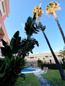 a resort with palm trees and a swimming pool at Costa del Golf in Torre de Benagalbón