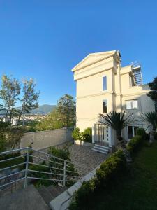 uma casa branca com uma cerca à frente. em Villa 35 em Tirana