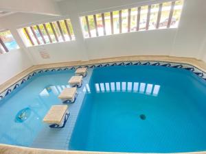 une grande piscine avec des chaises longues et une piscine dans l'établissement Hotel Lu Acapulco, à Acapulco