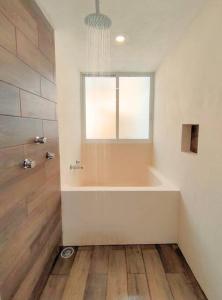 a bathroom with a bath tub and a window at Casa Colibri Central Villa with Private Pool and Tub Merida in Mérida +13 photos