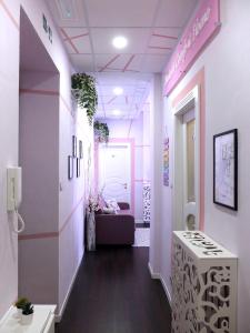 un pasillo con paredes rosas y blancas y una sala de espera en Turin Comfort Home en Turín