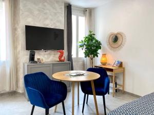 - un salon avec une table et deux chaises bleues dans l'établissement Coeursanary, à Sanary-sur-Mer