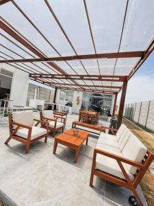eine Gruppe von Stühlen und Tischen auf einer Terrasse in der Unterkunft SOLARIUM CHINCHA Casa de Campo y Playa de 1000mts! in Sunampe