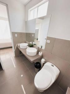 a bathroom with a white toilet and a sink at SOLARIUM CHINCHA Casa de Campo y Playa de 1000mts! in Sunampe