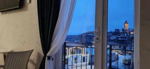 a room with a window with a view of a city at Guest House Alazani Valley in Sighnaghi